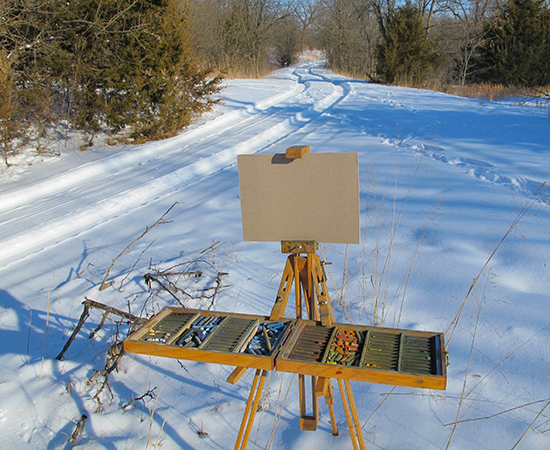 Photo of John Hulsey's plein air pastel set up in the winter snow ready to begin painting